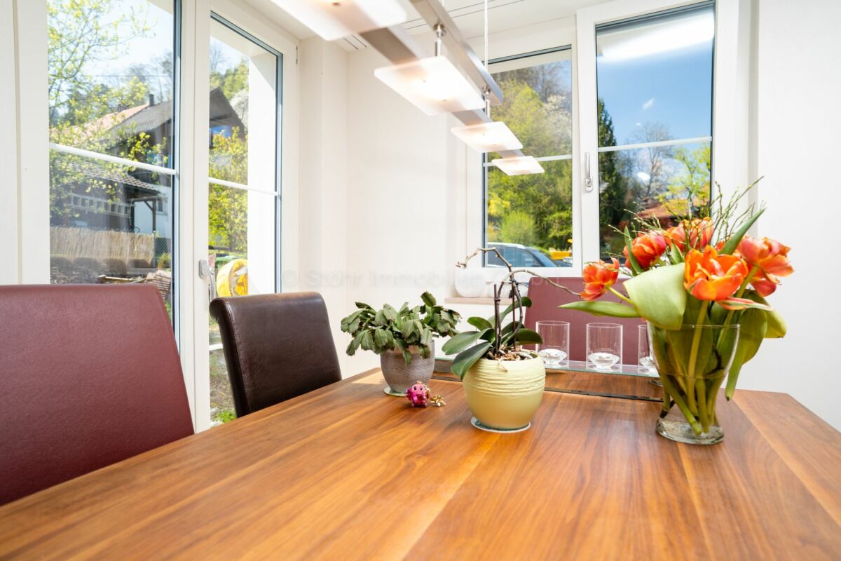 Essbereich mit Holztisch und Blumen