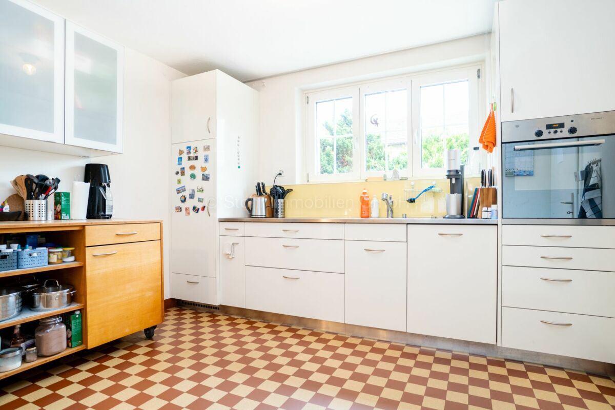 Helle Küche mit weißen Fronten und Retro-Boden