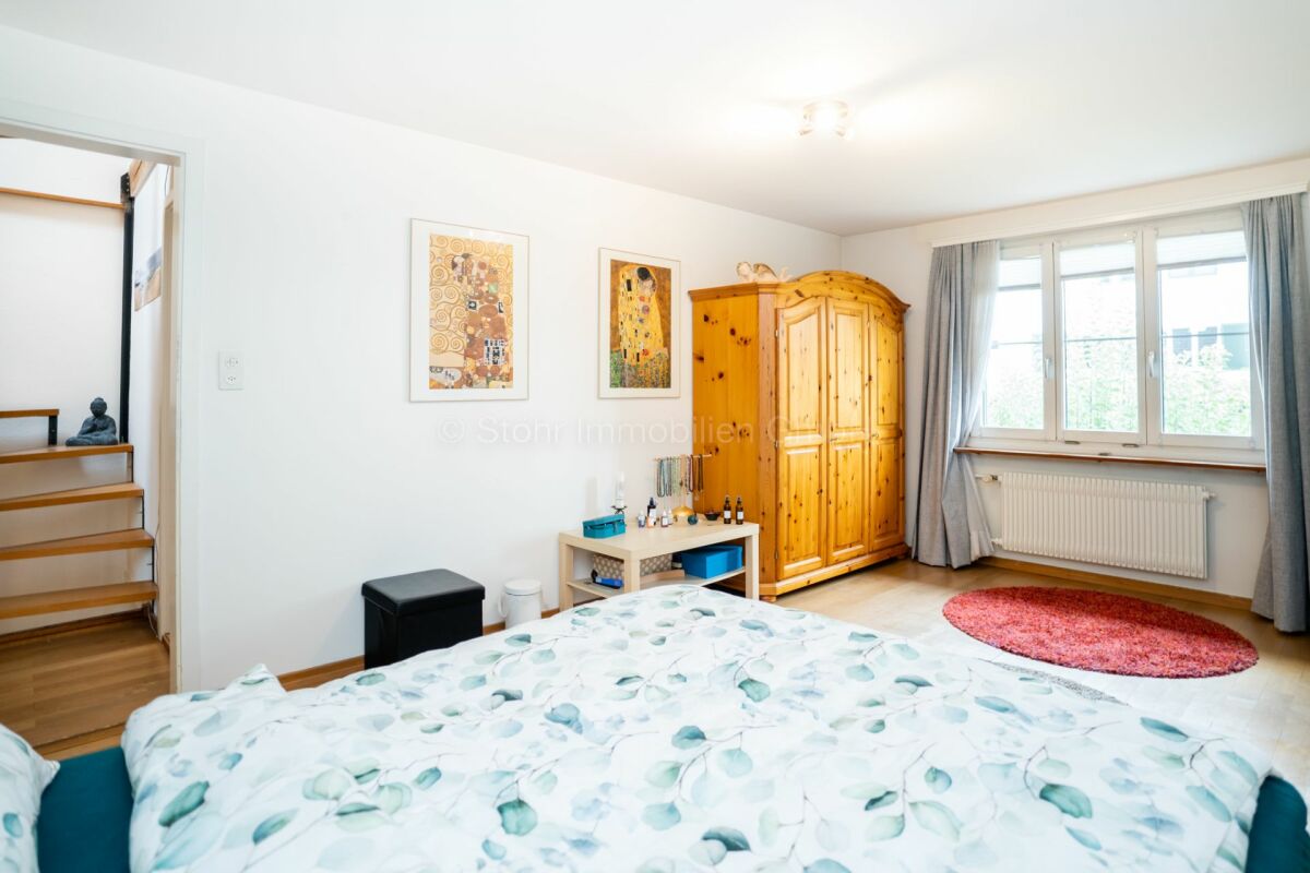 Helles Schlafzimmer mit Holzschrank und Fenster