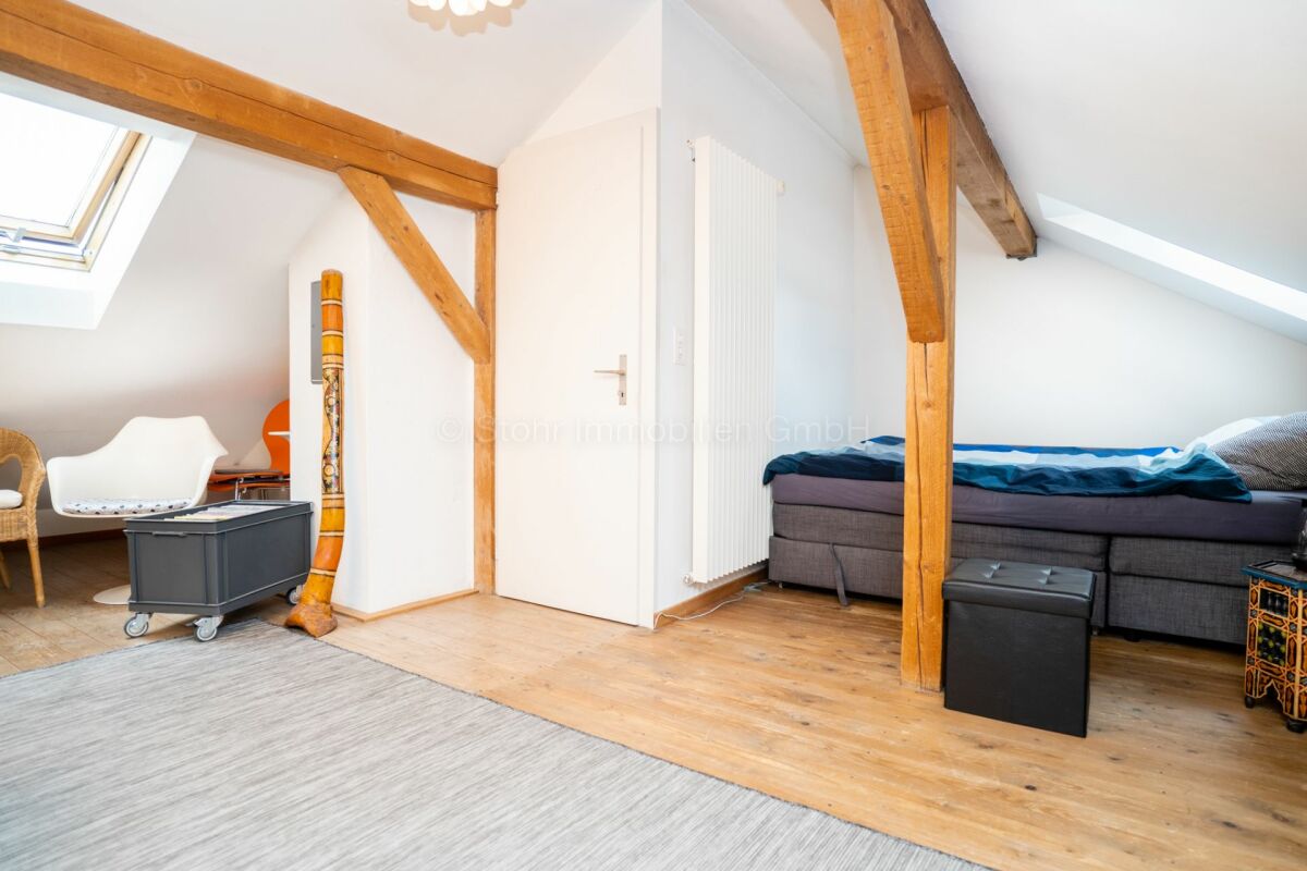 Dachgeschoss-Schlafzimmer mit sichtbaren Holzbalken