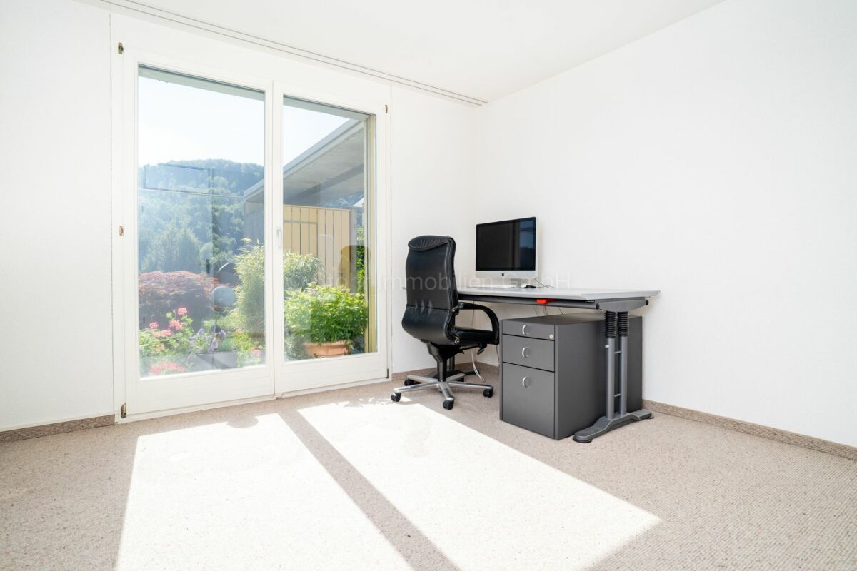 Helles Zimmer mit bodentiefem Fenster und Schreibtischecke