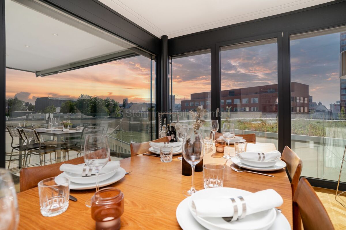 Essbereich mit Panoramaverglasung bei Sonnenuntergang