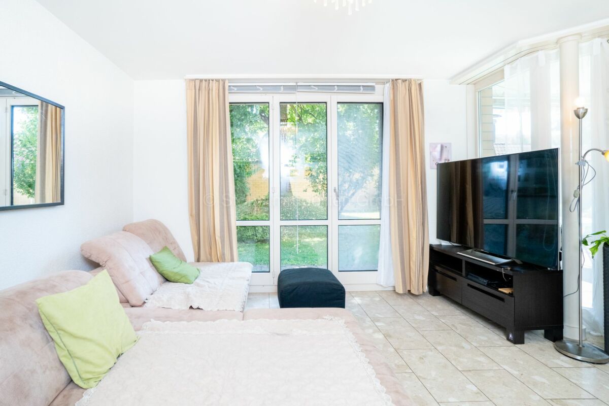 Helles Wohnzimmer mit Sofa und Fernseher