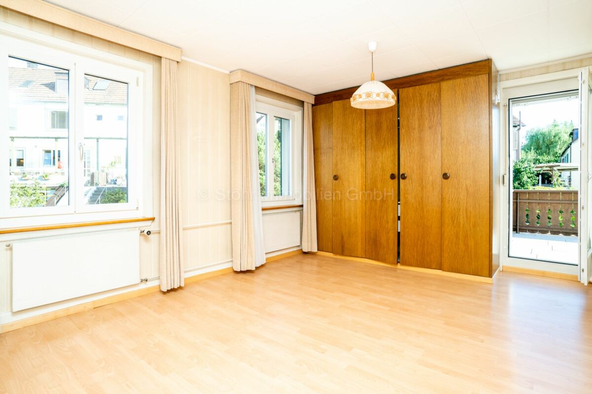 Helles leeres Zimmer mit Holzschrank und Balkon