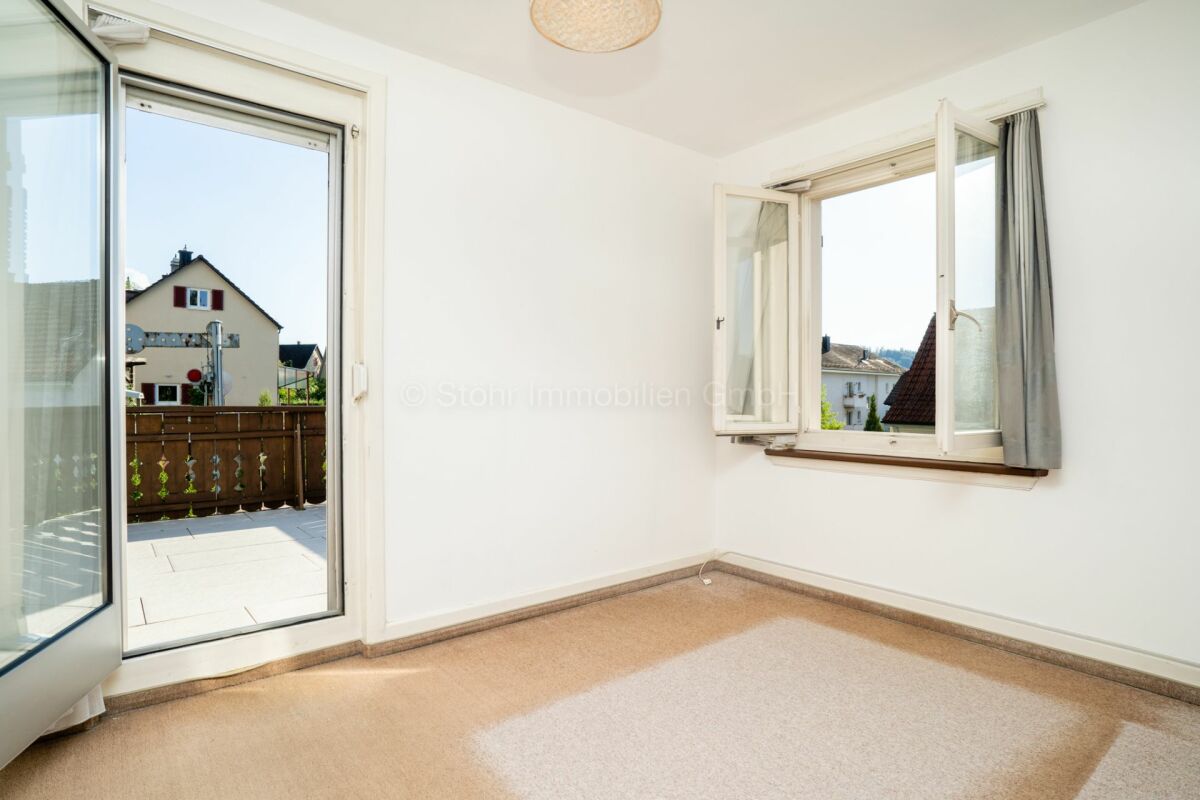Heller leerer Raum mit geöffneten Fenstern und Balkon-/Terrassentür