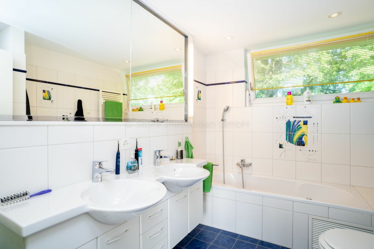 Helles Badezimmer mit Doppelwaschbecken und Badewanne