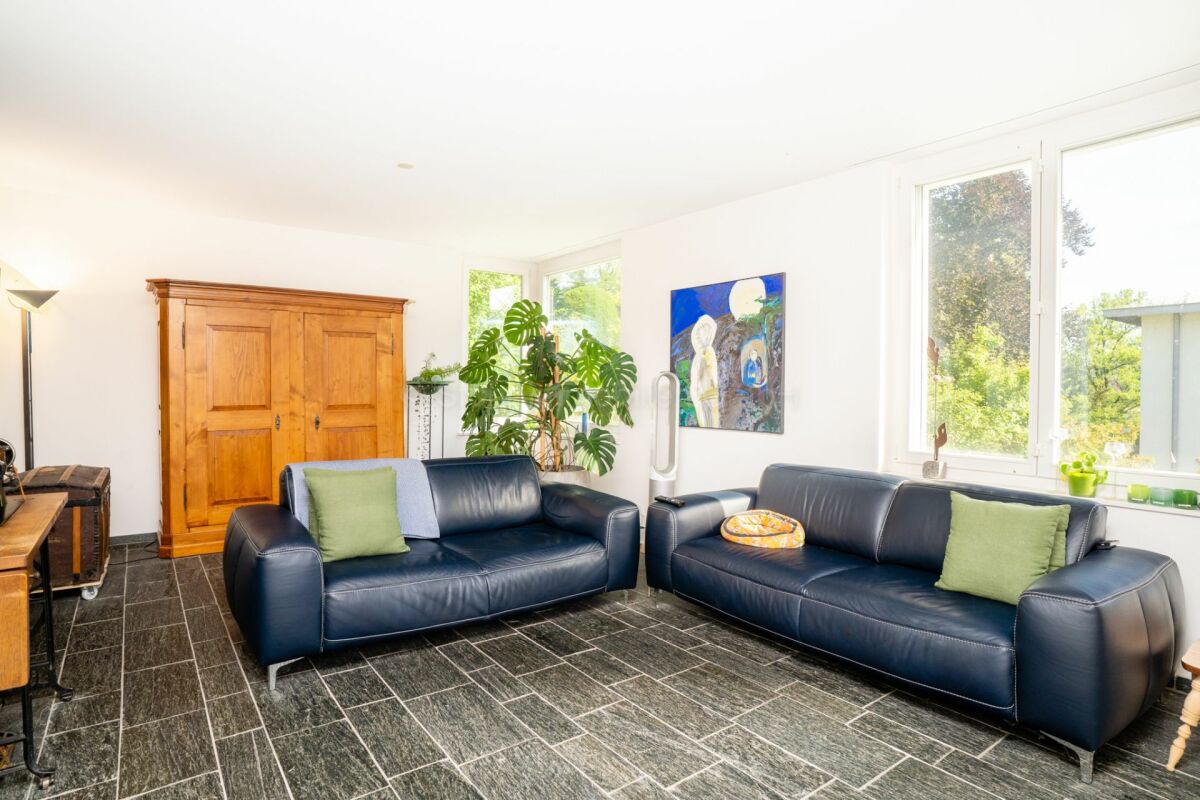 Heller Wohnraum mit zwei dunkelblauen Sofas und großem Holzschrank