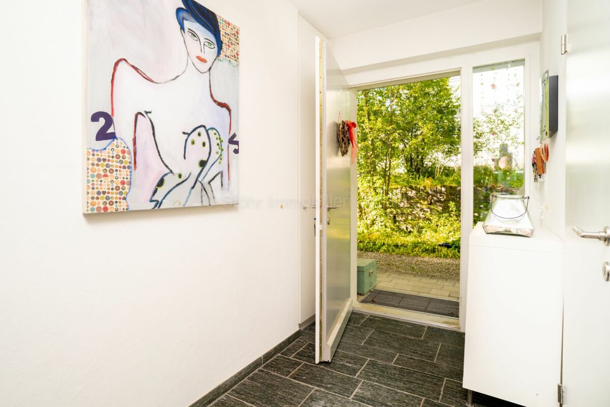 Eingangsbereich mit geöffneter Haustür zum Garten