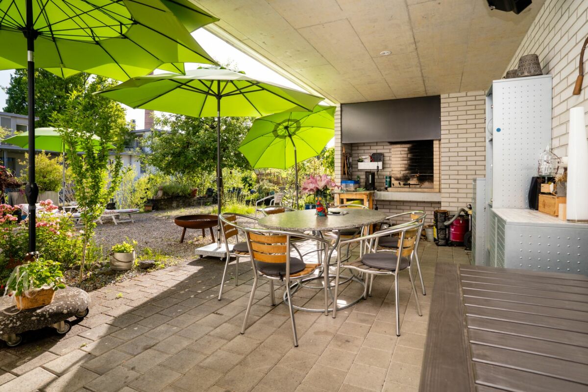 Überdachte Terrasse mit Grill und Sitzgruppe