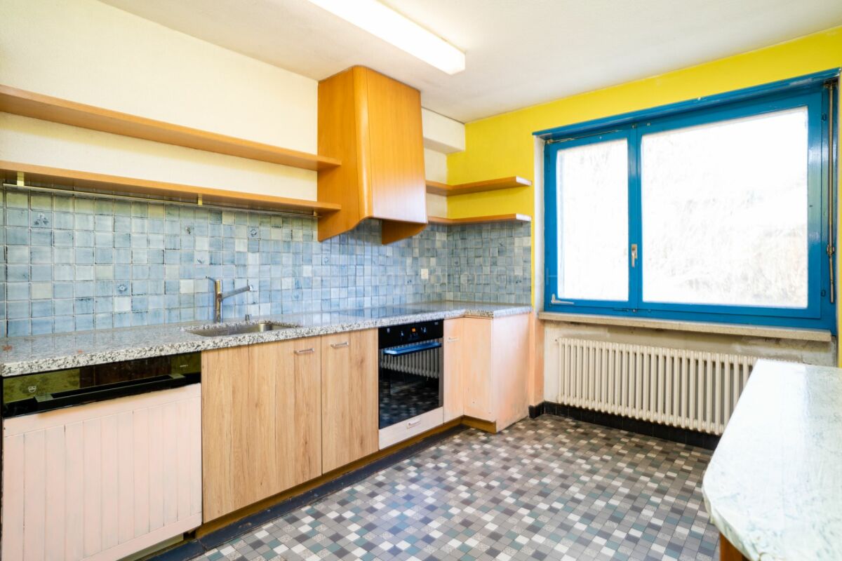 Küche mit gelber Wand, blauen Fenstern und Holzfronten