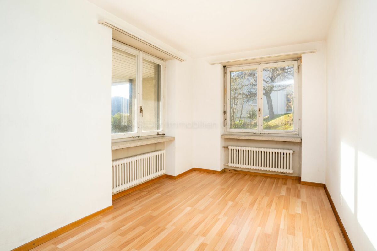 Helles, leeres Zimmer mit zwei Fenstern