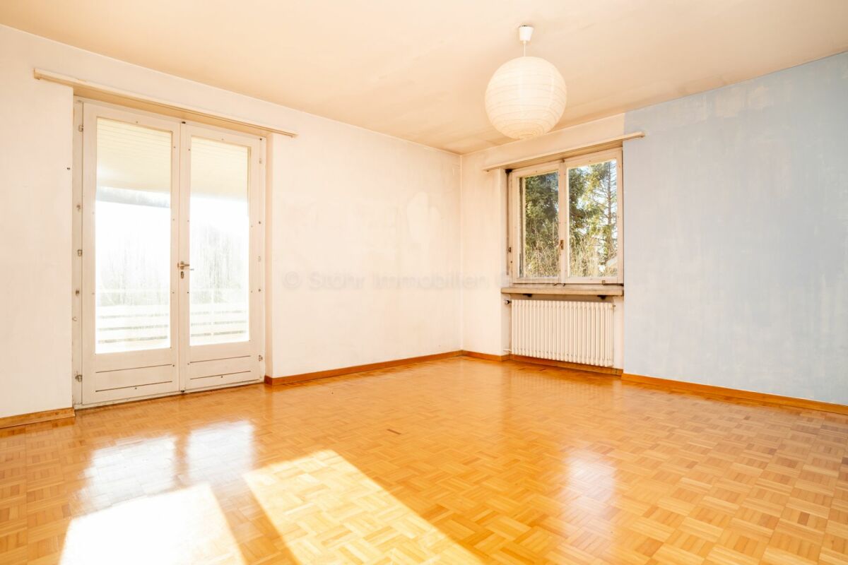 Heller leerer Wohnraum mit Balkon- und Fensterfront