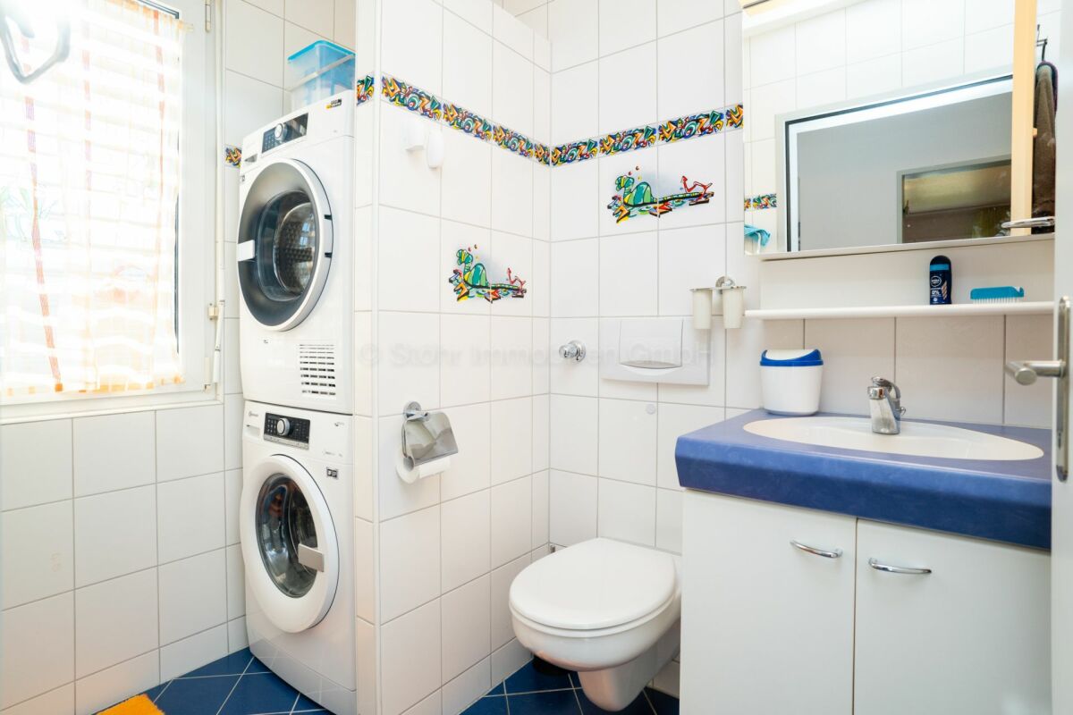 Modernes Gäste-WC mit Waschmaschine und Trockner