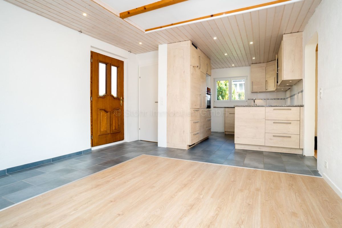 Helle Wohnküche mit Holztür und modernen Fronten