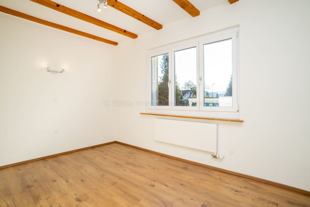 Heller leerer Raum mit Holzdecke und Fenster