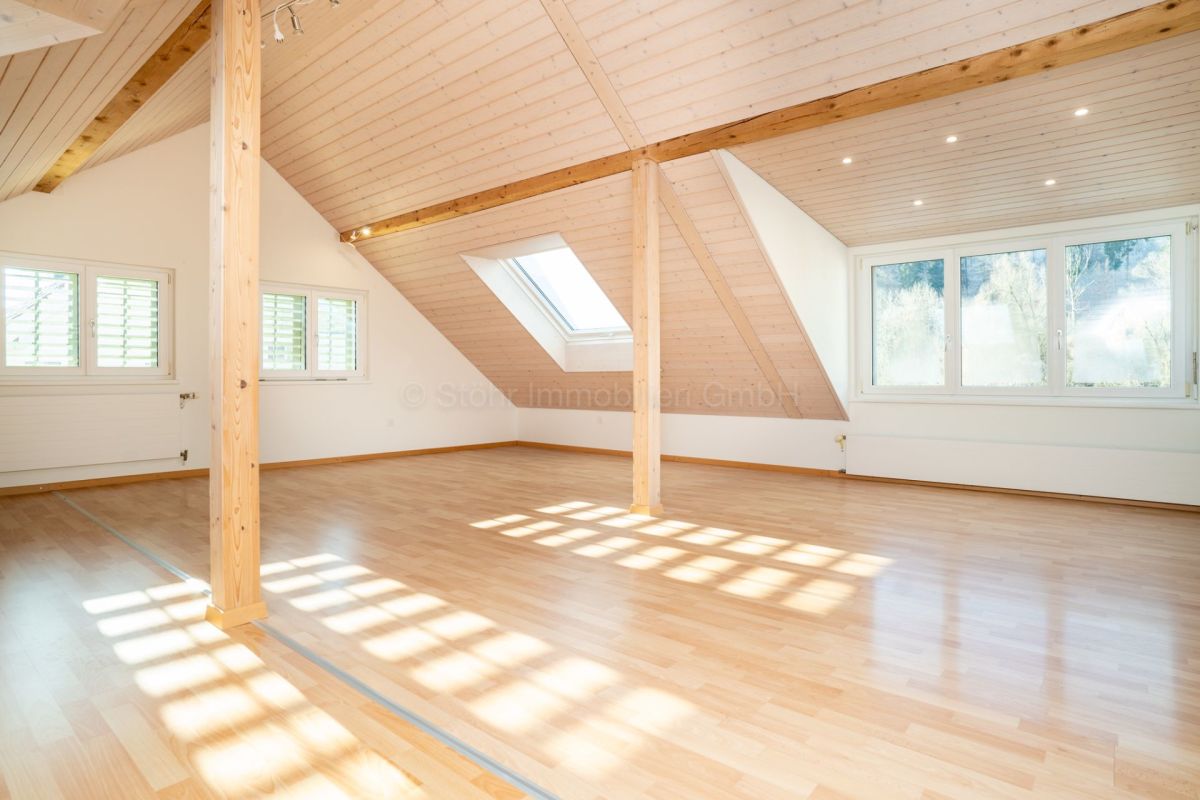 Heller ausgebauter Dachraum mit Holzdecke und Dachfenster
