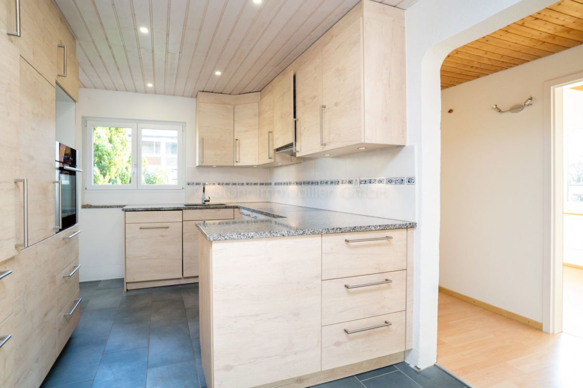 Helle Küche mit Holzoptik und Naturstein-Arbeitsplatten