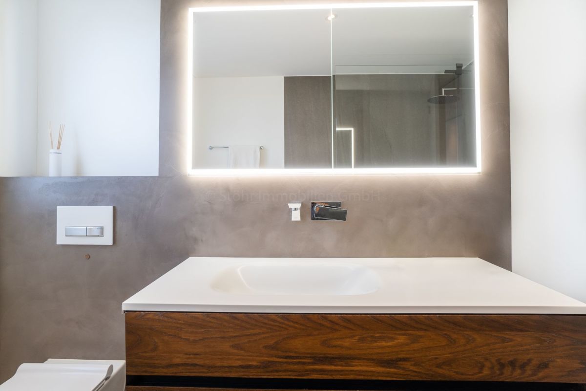 Modernes Badezimmer mit beleuchtetem Spiegel