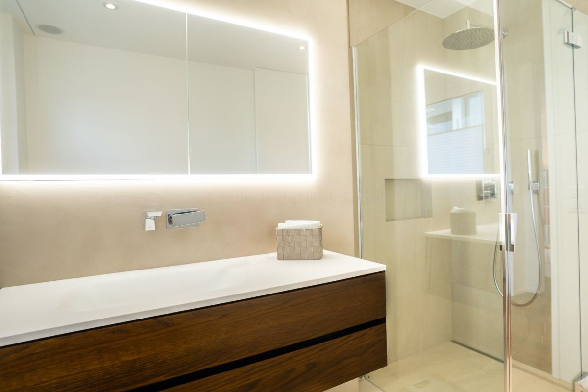 Modernes Badezimmer mit LED-Spiegel und Glasdusche