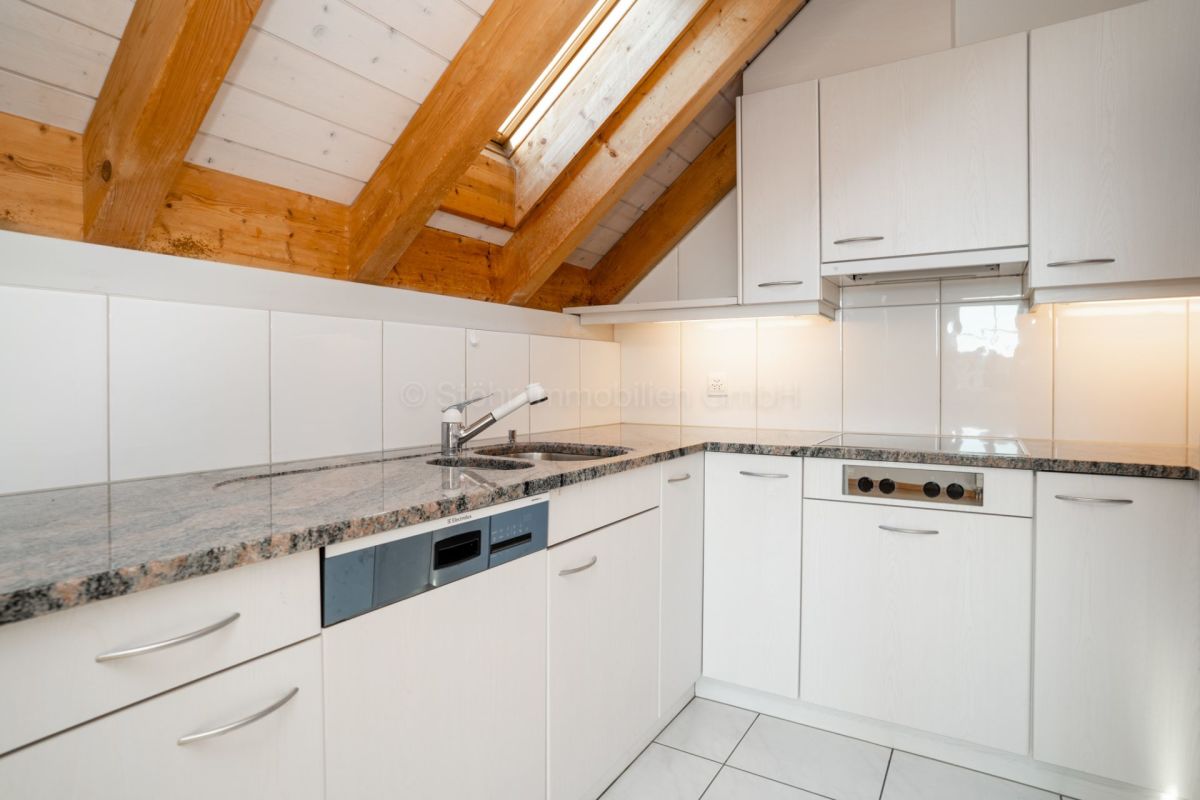 Helle Dachgeschossküche mit sichtbaren Holzbalken