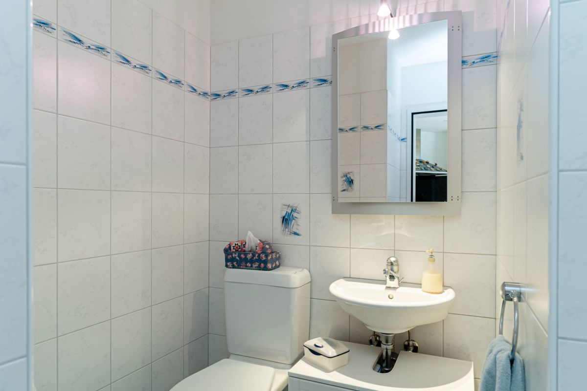 Gäste-WC mit Fliesen und Waschbecken