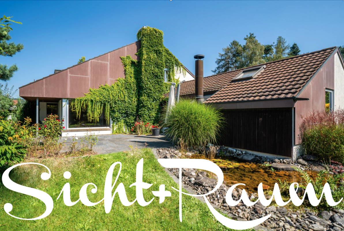 Außenansicht eines begrünten Wohnhauses mit Nebengebäude