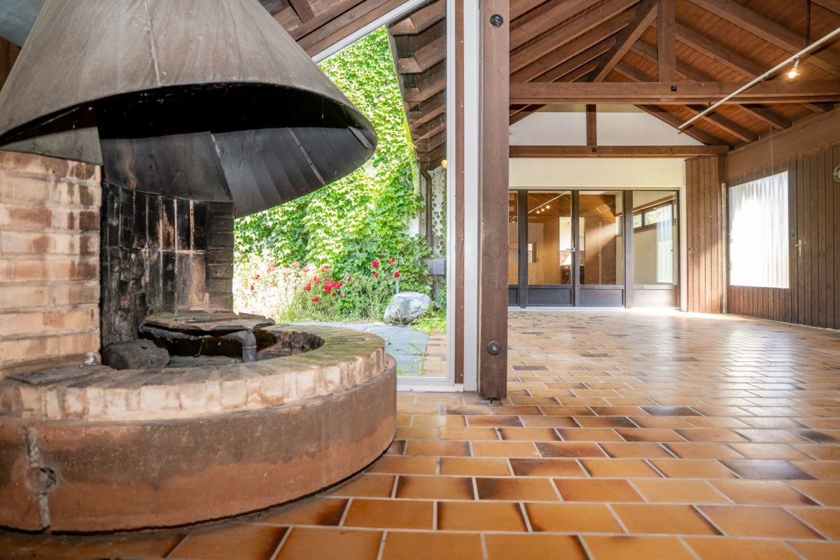 Terrasse mit gemauertem Außenkamin und überdachtem Holzbereich
