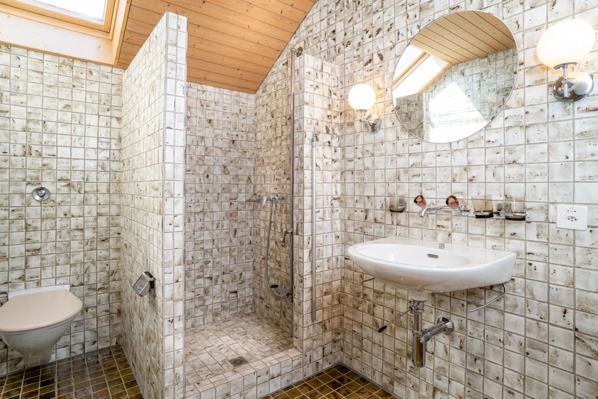 Badezimmer mit mosaikartigen Fliesen und Dachfenster