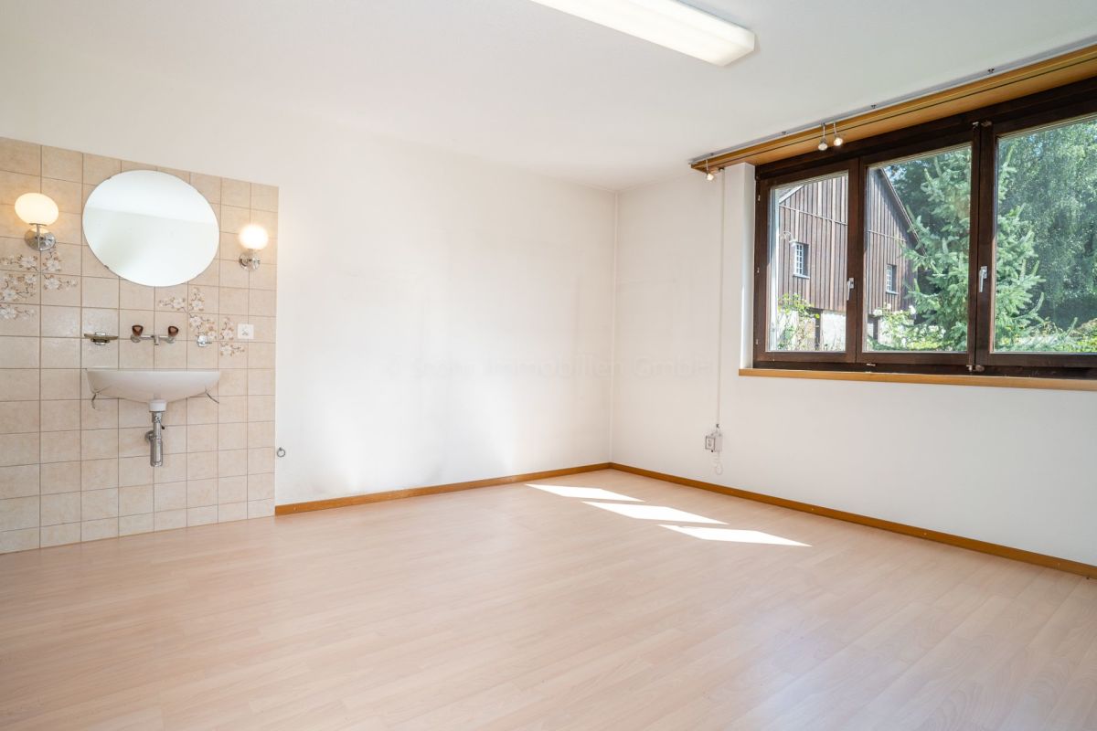 Helles, leeres Zimmer mit Fenster und Waschplatz