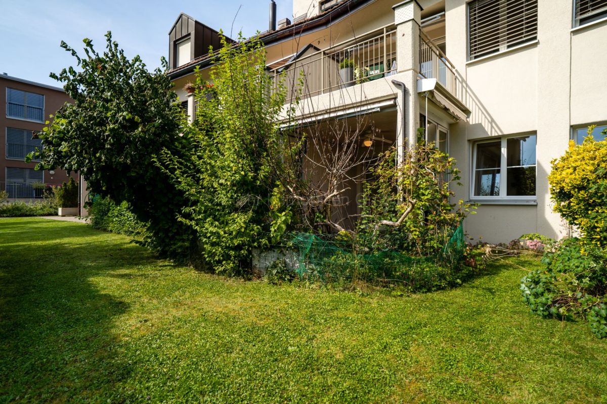 Gartenansicht eines Wohnhauses mit Balkon