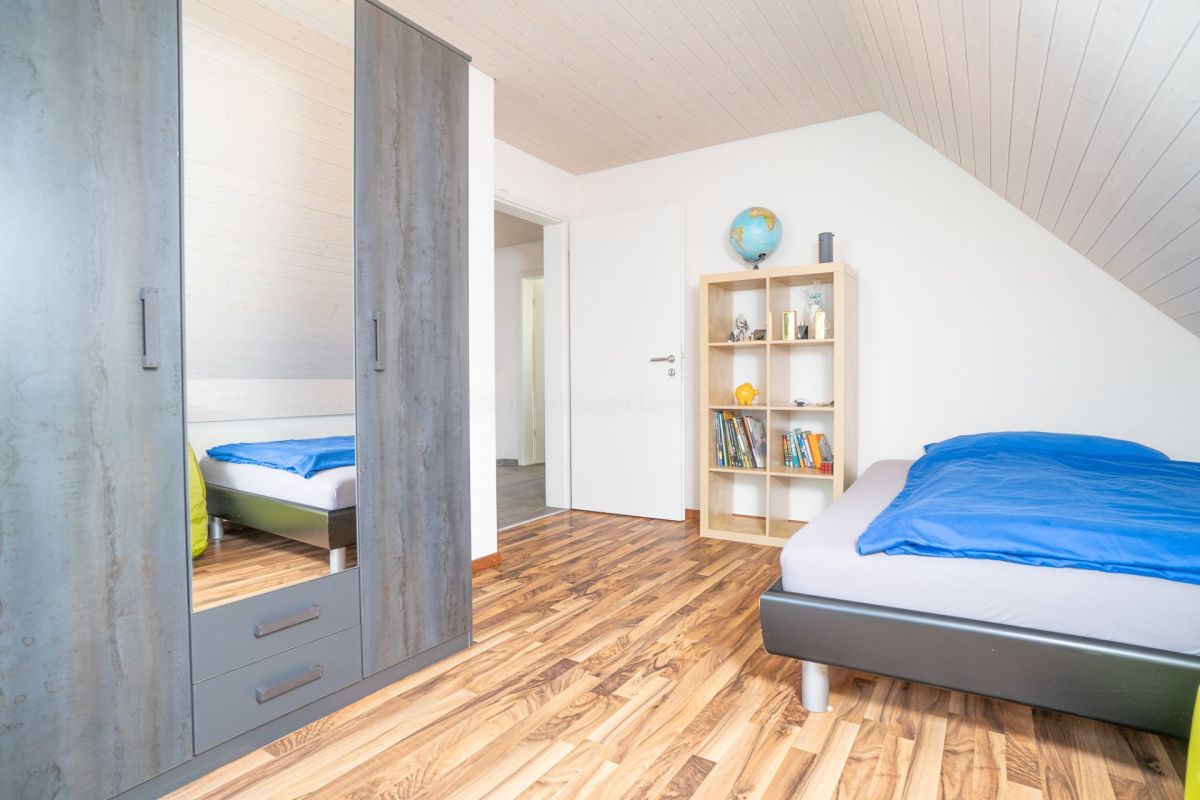 Dachgeschoss-Schlafzimmer mit Holzoptikboden