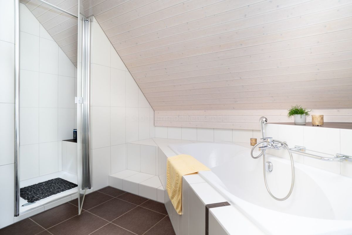 Modernes Badezimmer mit Badewanne und Dusche unter Dachschräge