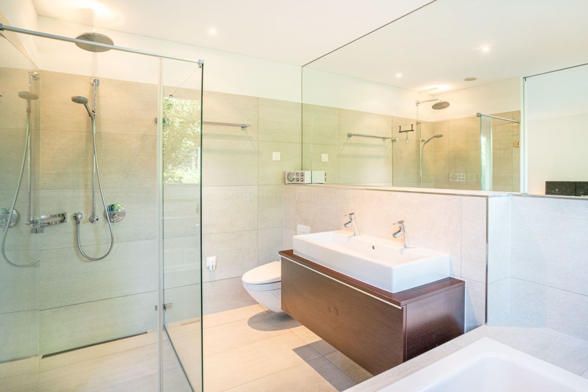Modernes Badezimmer mit Glasdusche und Doppelwaschbecken