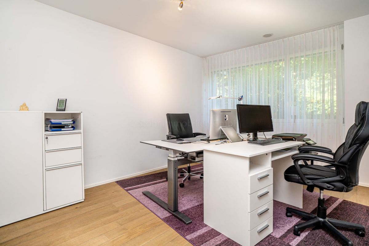 Helles Büro mit Schreibtisch und Fensterfront