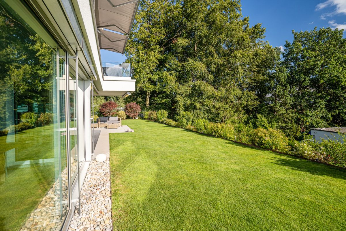 Moderne Gartenansicht mit Terrasse und großer Glasfront