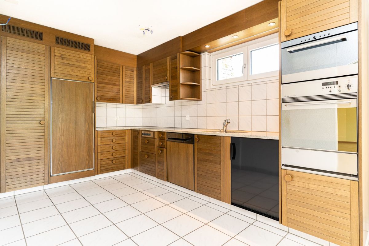 Küche mit Holzfronten und weiß gefliestem Boden