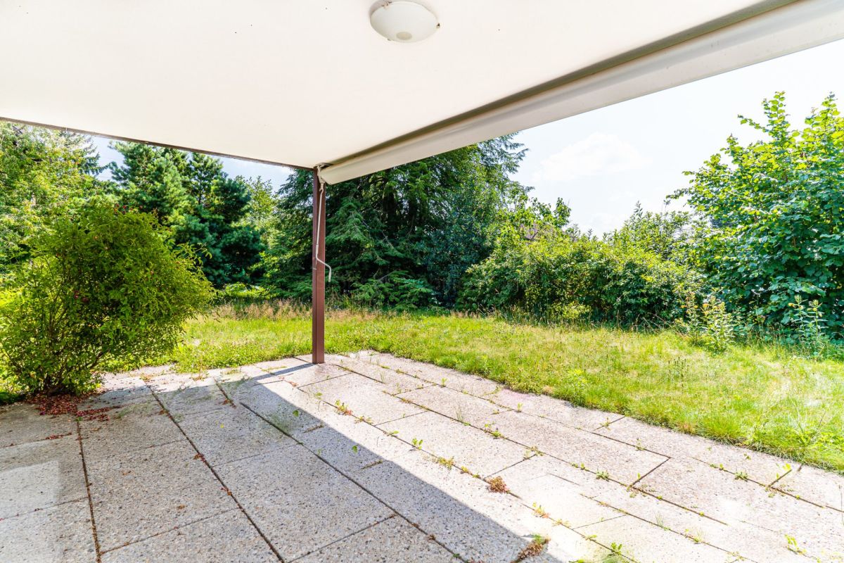Überdachte Terrasse mit Gartenblick