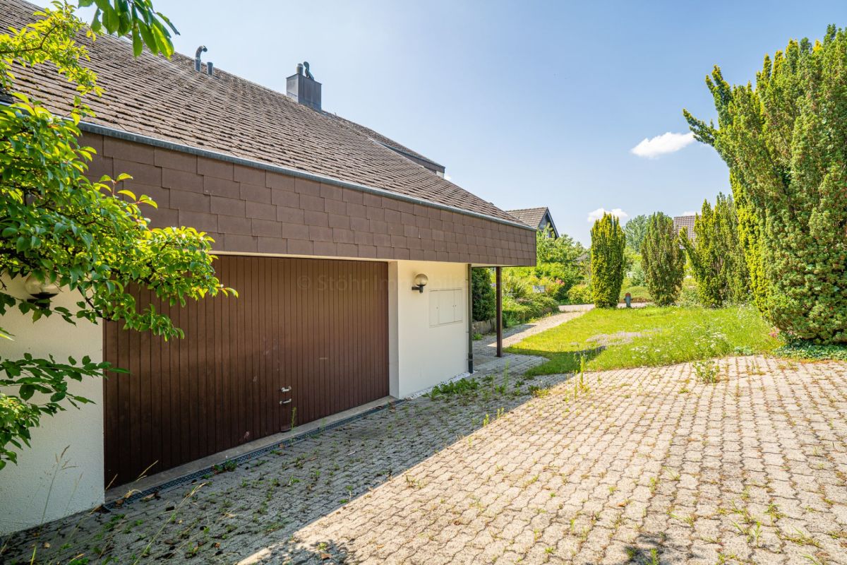 Garagenzufahrt und Gartenansicht eines Hauses