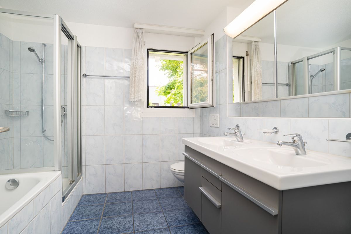 Helles Badezimmer mit Doppelwaschtisch und Badewanne
