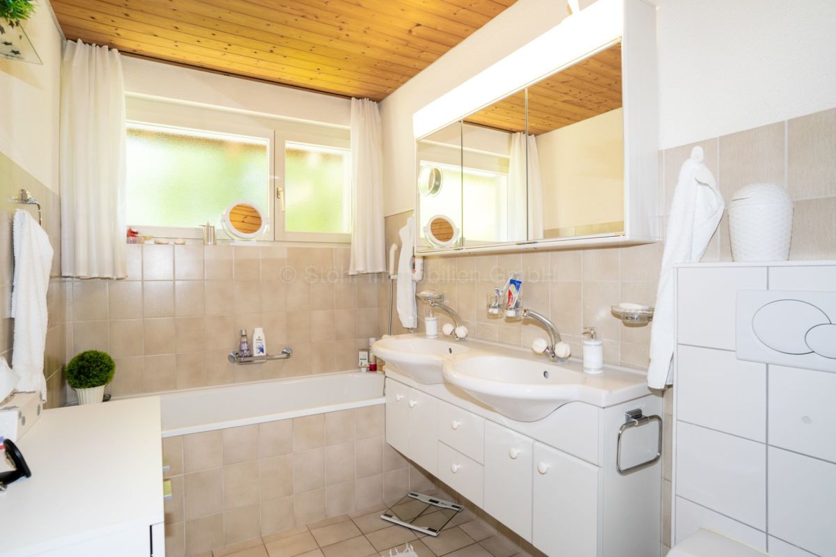 Badezimmer mit Doppelwaschtisch und Badewanne