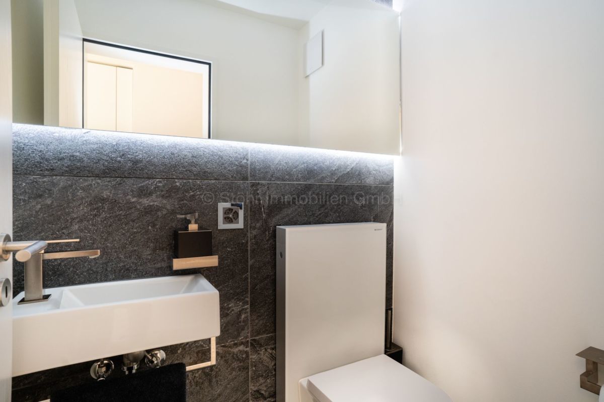 Modernes Gäste-WC mit dunkler Natursteinverkleidung