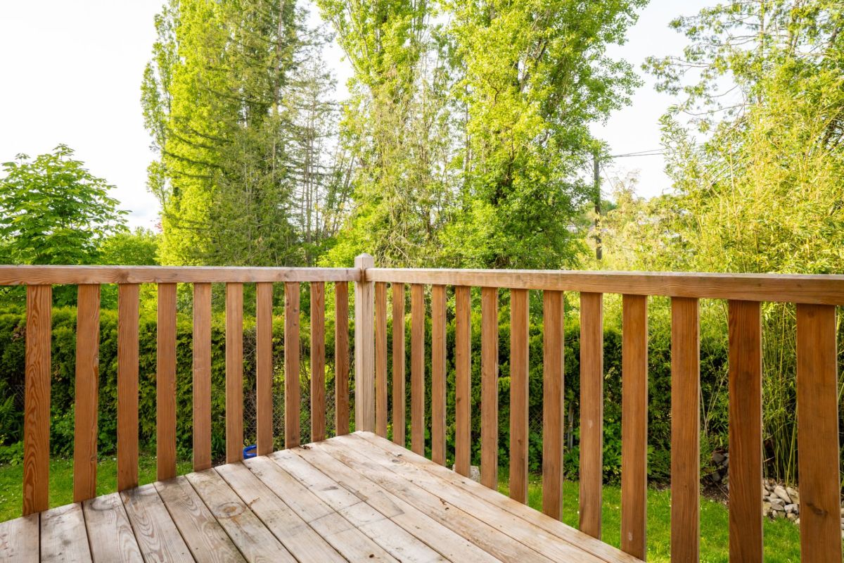 Holzterrasse mit Geländer und Gartenblick
