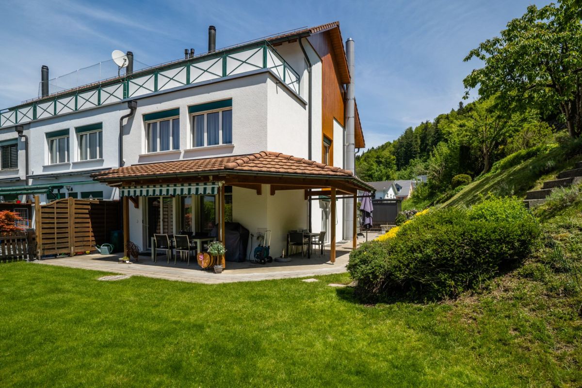 Gartenansicht eines Wohnhauses mit überdachter Terrasse