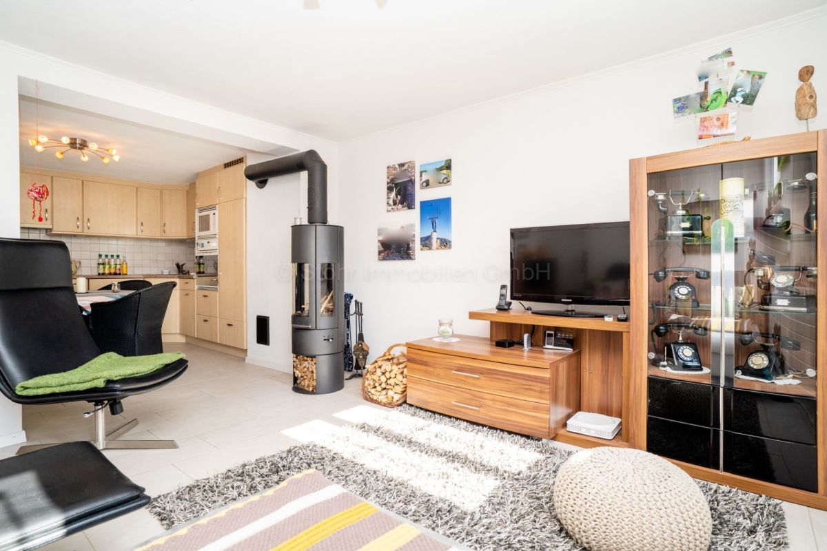 Wohnzimmer mit offener Küche und Kaminofen