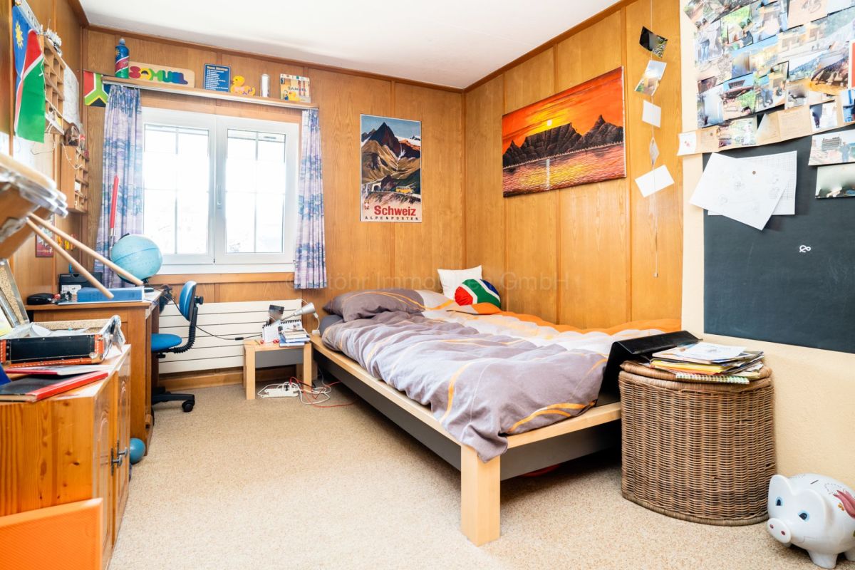 Jugendzimmer mit Holzwänden und Einzelbett