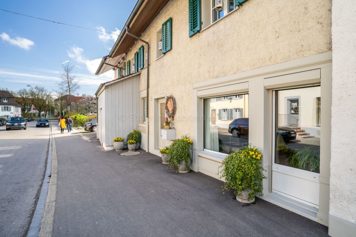 Straßenansicht eines Wohnhauses mit kleiner Vorgartenzone