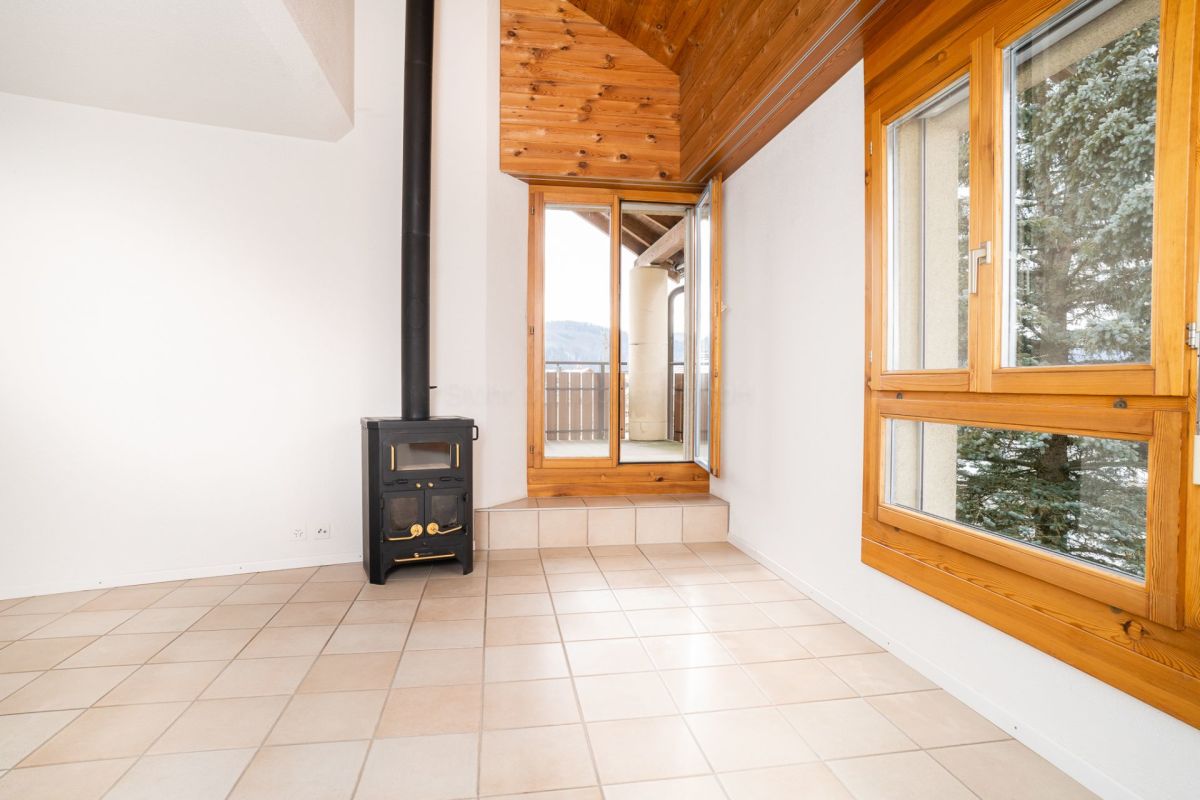 Heller Raum mit Holzofen und Dachfenstern