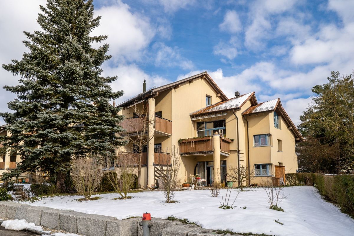 Mehrfamilienhaus mit verschneitem Vorgarten