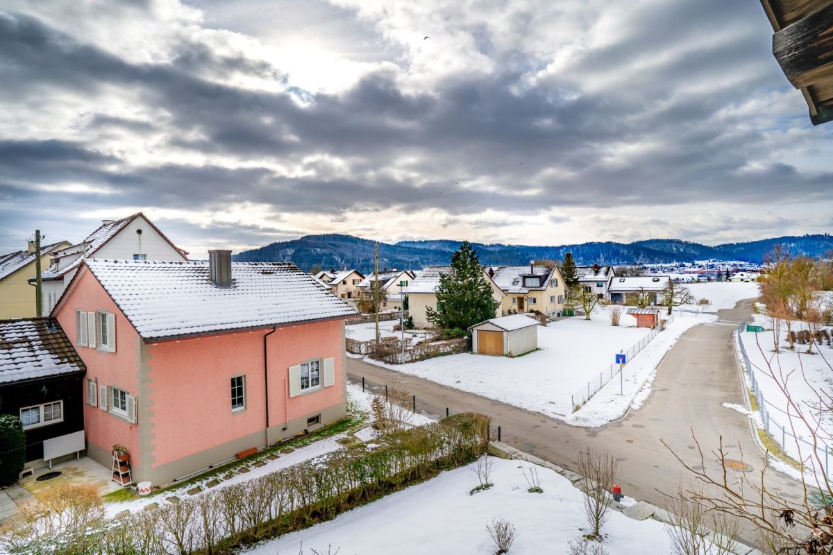 Verschneite Wohnhäuser mit Bergblick