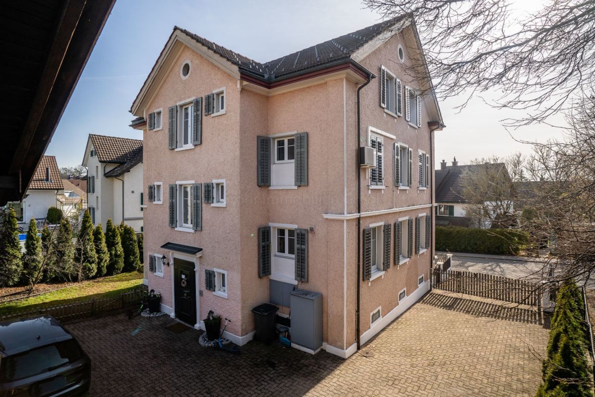 Pastellfarbenes Wohnhaus mit Satteldach und Fensterläden